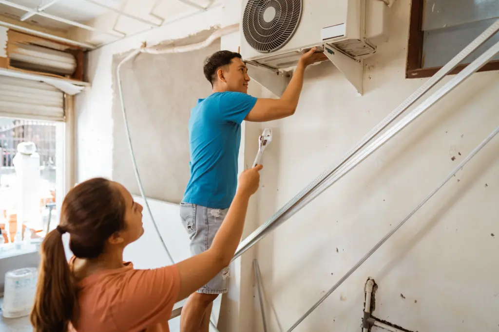 stock-photo-young-couple-repairing-their-own-air-conditioner-during-their-work-break-at-home-2412945877