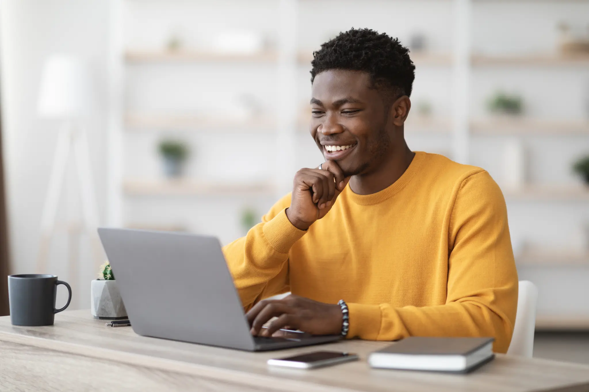 stock-photo-happy-black-guy-project-manager-sitting-at-workdesk-at-office-typing-on-laptop-keyboard-and-2100706477