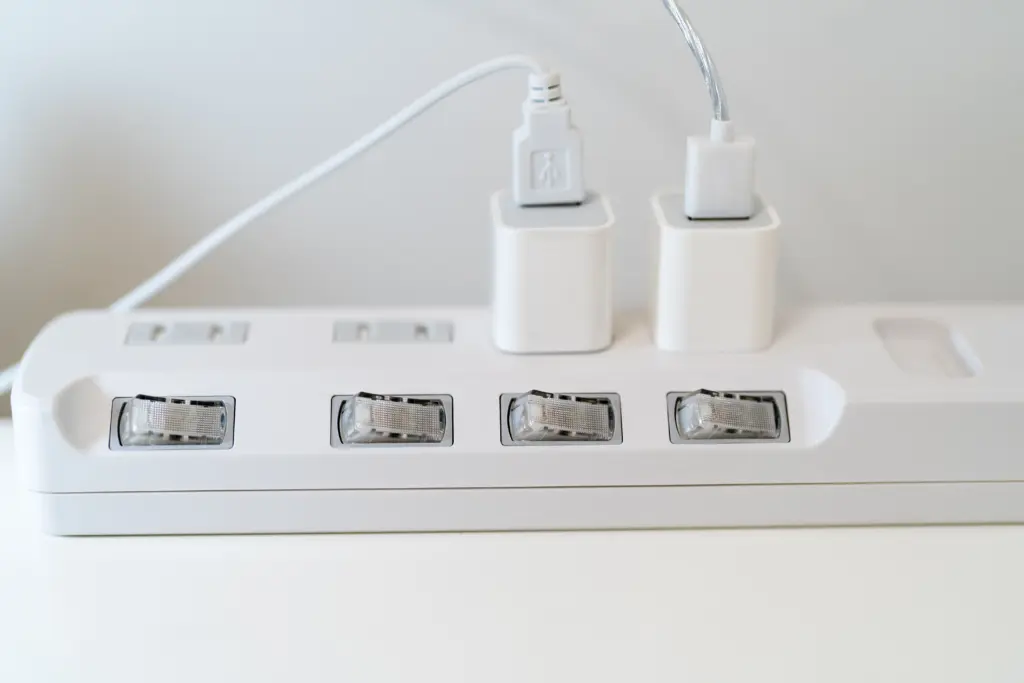 stock-photo-insert-the-charging-cable-into-the-multi-plug-place-a-white-power-strip-in-one-corner-of-the-desk-2149753125