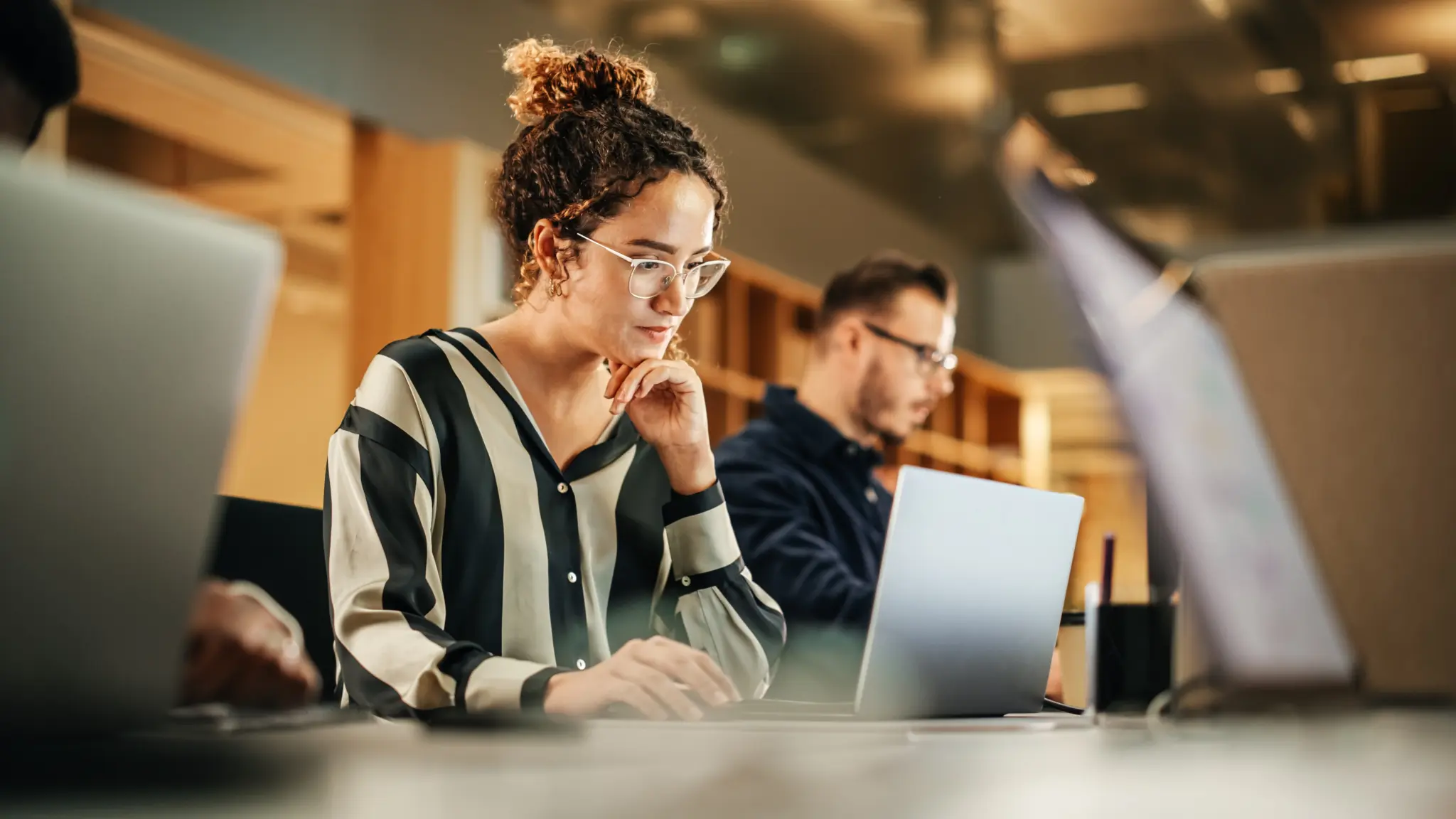stock-photo-portrait-of-enthusiastic-hispanic-young-woman-working-on-computer-in-a-modern-bright-office-2242410029